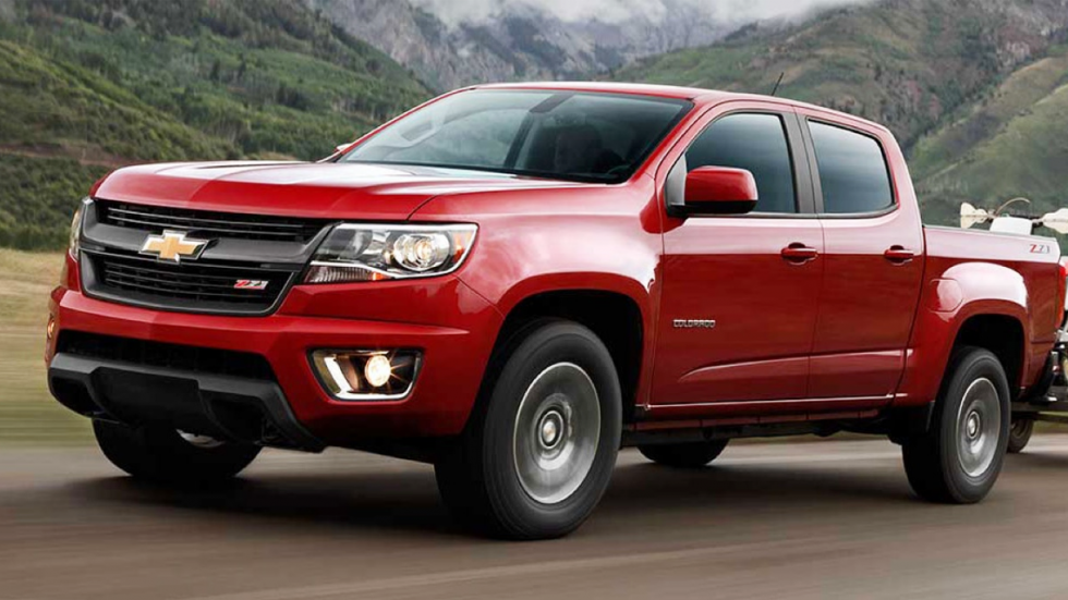2015 Red Chevy Colorado pulling trailer in mountains