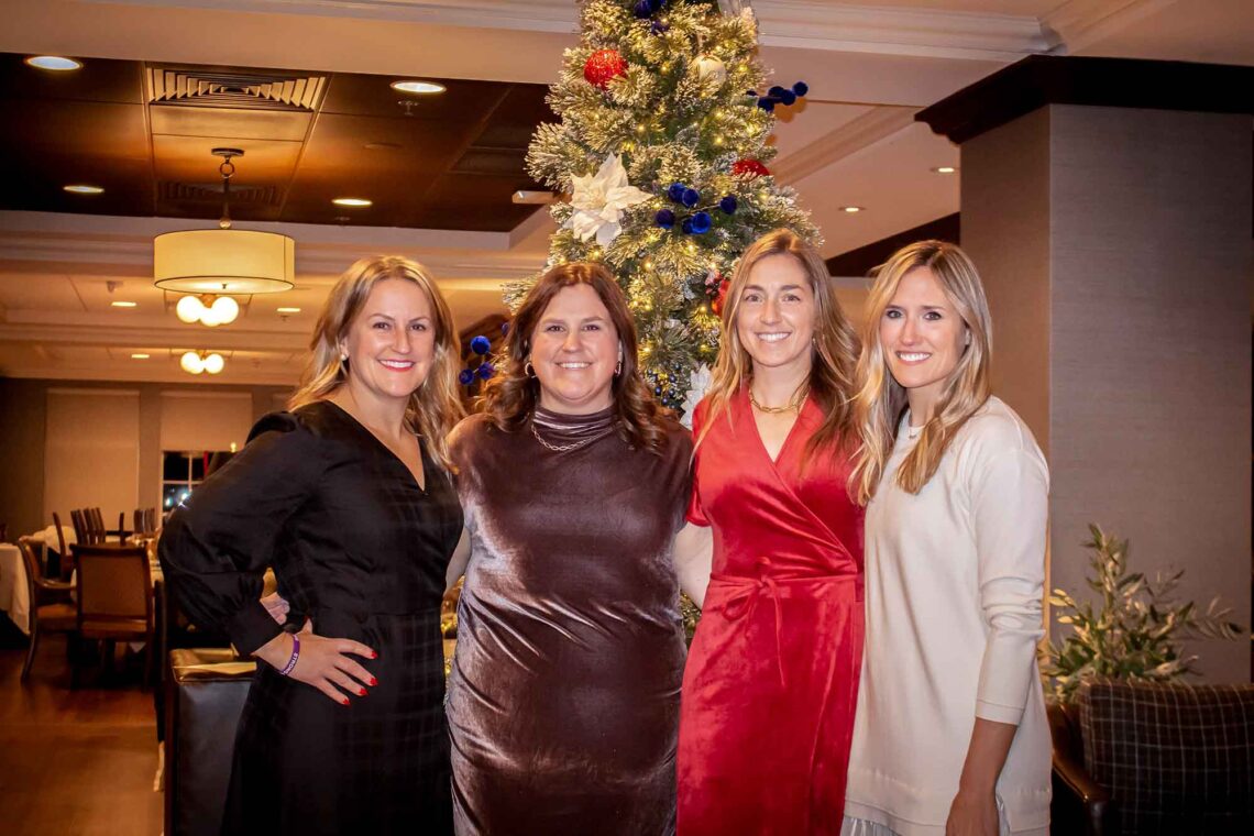 Lindsay McGrath, Jaymie McGrath and friends posing in front of a Christmas tree
