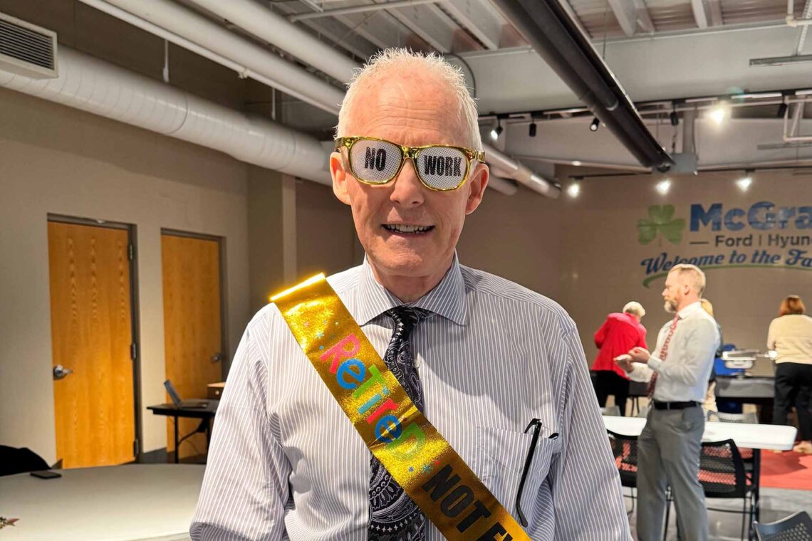Rick Sayre wearing a sash and retirement themed glasses